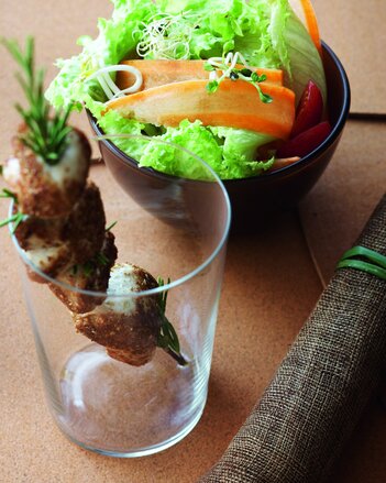 Auf dem Foto ist eine Schüssel mit Salat zu sehen. Daneben steht ein Glas, in dem ein Hühnchen-Spieß zu sehen ist. | © SONNENTOR