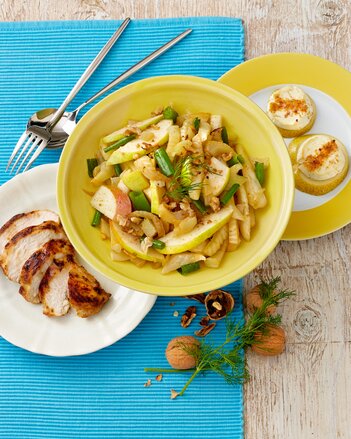 Auf dem Foto ist eine Schale mit Fenchel-Birnen-Salat zu sehen. Daneben ist ein Teller mit mariniertem Huhn. | © SONNENTOR