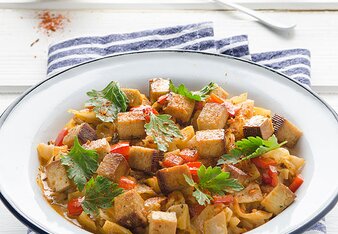 Auf dem Foto ist ein Teller mit Paprika-Rahmkraut mit Tofu zu sehen. Das Teller steht auf einem blau-weißen Tuch. | © SONNENTOR