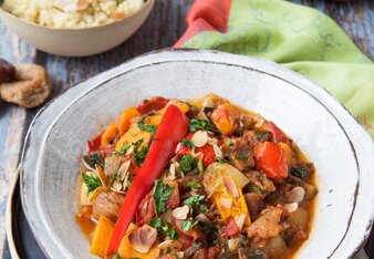 Auf dem Foto ist ein Teller mit Habeshas vegetarischer Tajine. Dahinter ist eine Schale mit Couscous zu sehen. | © SONNENTOR