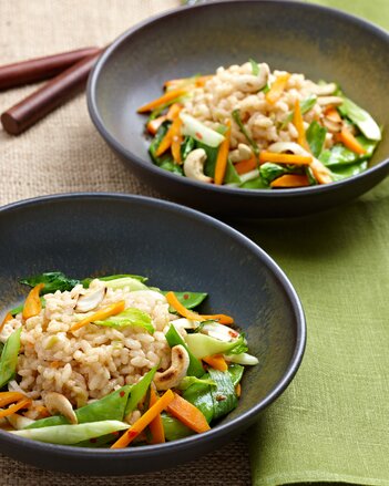 Auf dem Foto sieht man zwei Teller mit Wongs Risotto. Darauf sind Cashewnüsse und Gemüse zu sehen. | © SONNENTOR