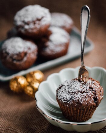 Auf dem Foto sieht man einen Lebkuchen Muffins in dem eine Gabel steckt. Im Hintergrund sieht man noch mehrere Muffins. | © SONNENTOR