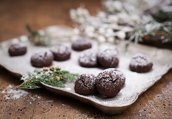 Auf dem Foto sind kleine Cookies auf einem Silber-Tablett zu sehen. Daneben sind grüne Zweige zu sehen. | © SONNENTOR