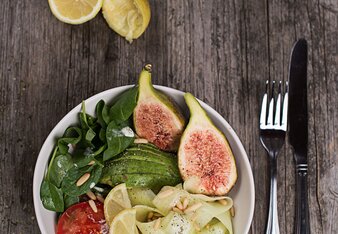 Auf dem Foto ist eine Bowl mit Feigen, Spinat, Tomaten und weiterem Gemüse zu sehen. Daneben sind Zitronen und ein Dip zu sehen. | © SONNENTOR