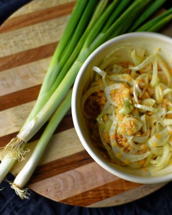 Auf dem Foto sieht man eine Schale mit Linsensalat und Fenchel. Daneben liegen Frühlingszwiebel. | © SONNENTOR