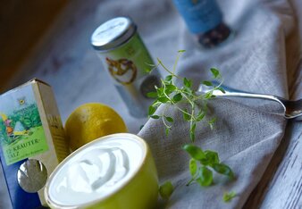 Auf dem Foto sieht man ein kleines Schälchen mit Kräuter-Dip. Daneben sieht man Sonnentor Gewürze wie Pfeffer bunt und das 12-Kräutersalz. | © SONNENTOR