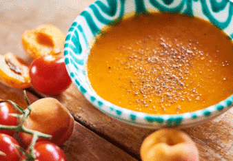 Auf dem Foto sieht man eine Schale mit Tomaten-Marillen Suppe. Daneben sieht man frische Tomaten und Marillen. | © SONNENTOR