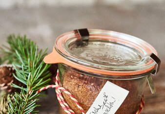 Auf dem Foto ist ein Glas mit Kuchen darin zu sehen. Daneben sind Zweige zu sehen und eine weiß-rote Schnur. | © SONNENTOR