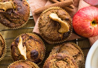 Auf dem Foto sieht man mehrere Muffins. Neben den Muffins sind auch ein Apfel und Zimtstangen zu sehen. | © SONNENTOR