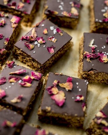 Auf dem Foto ist eine Amarantschnitte mit Schokolade zu sehen. Die Schnitten sind mit Rosenblüten verziert. | © SONNENTOR