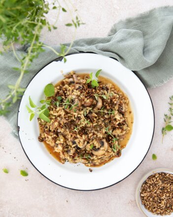 Auf dem Foto sieht man einen Teller mit veganem Steinpilz-Risotto. Das Risotto ist mit Thymian garniert. | © SONNENTOR