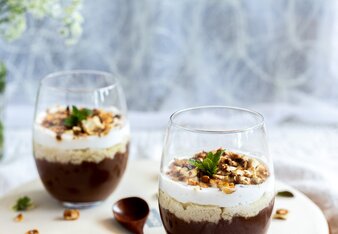 Auf dem Foto sieht man zwei Gläser mit Mousse au Chocolate. Sie sind mit Nüssen garniert. | © SONNENTOR