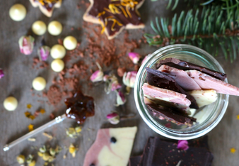 Auf dem Foto sieht man ein Glas mit veganer Spicy Gewürz-Schoko in heller, rosa und dunkler Farbe. | © SONNENTOR