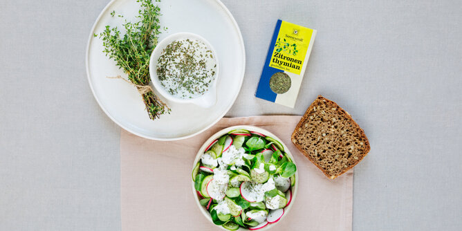 Auf dem Foto sieht man eine Schale mit Zitronenthymian Dressing. Daneben steht eine Schüssel Salat mit dem Dip darauf. | © SONNENTOR