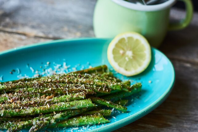 Auf dem Foto ist gegrillter grüner Spargel zu sehen. Er ist mit Parmesan bestreut. | © SONNENTOR