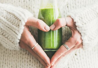 Auf dem Foto sieht man wie eine Frau eine Flasche mit grünem Smoothie in den Händen hält. | © SONNENTOR